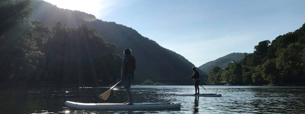 2 people on stand up paddle boarders on the river