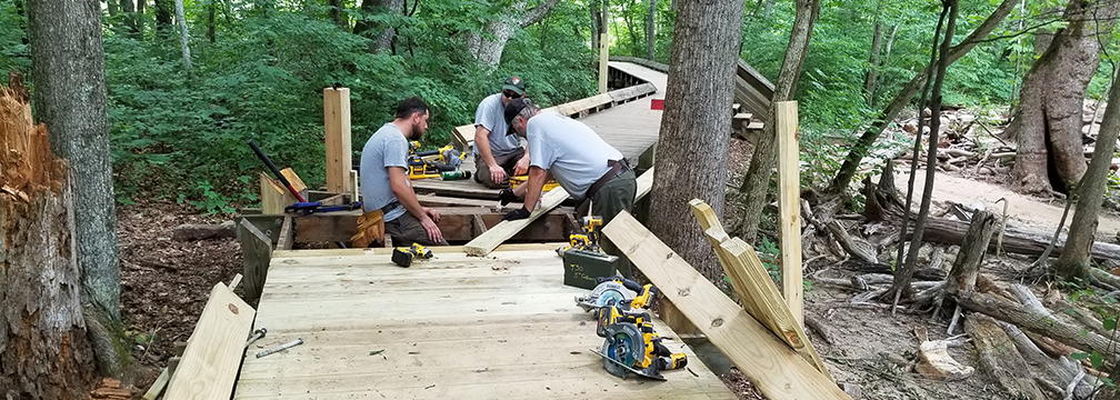 maintenance crew repairing a boardwalk