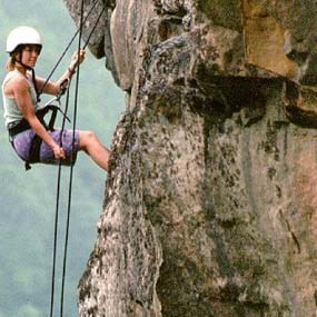 woman rappelling down cliff