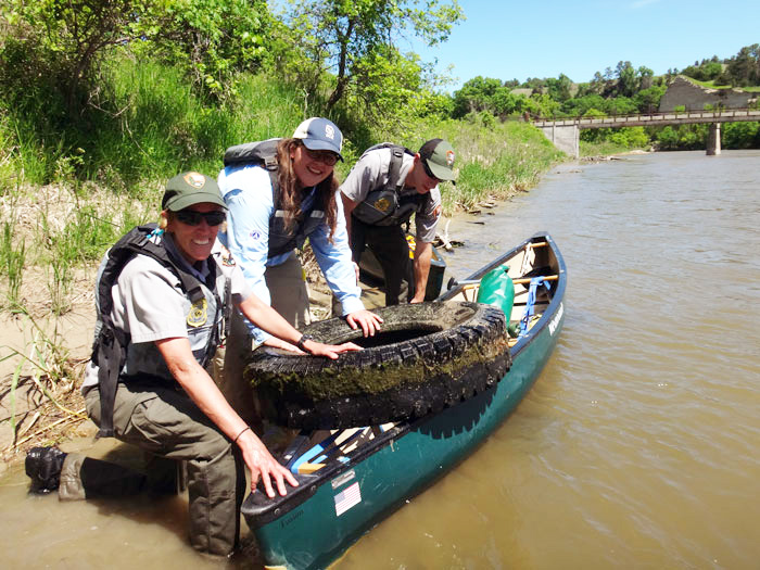 Three rangers show of a tire in their canoe