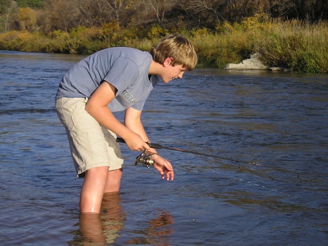 Angler reaches into water