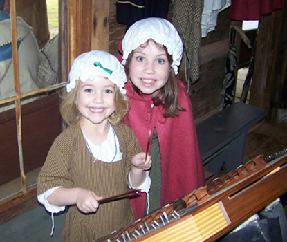 Musical sisters enjoy hammer dulcimer.