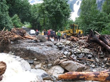 Road debris in foreground with multiple people on other side.