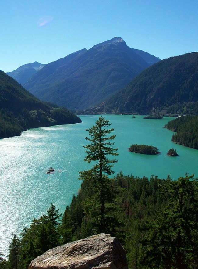 scenic view of aquamarine colored lake and mountains