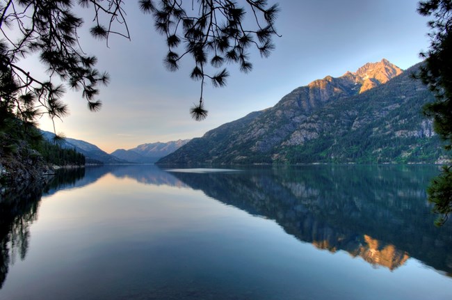 calm lake surface and early morning light on mountains