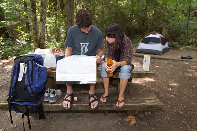 A young man and woman consult a map in their campsite at the Colonial Creek Campground before taking a day hike. Photo Credit: NPS/David Snyder A young man and woman consult a map in their campsite at the Colonial Creek Campground before taking a day hike. Photo Credit: NPS/David Snyder
