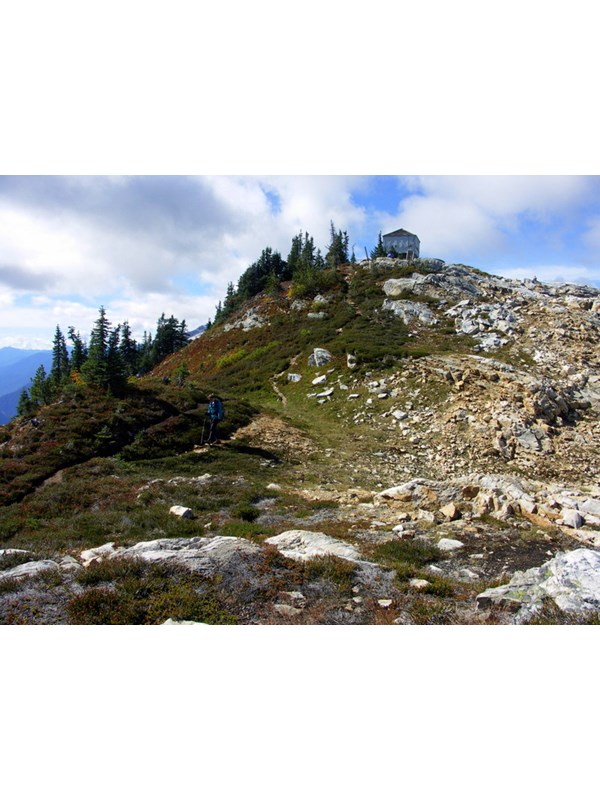 A hiker below Sourdough Mountain Lookout, heading toward Pierce Mountain