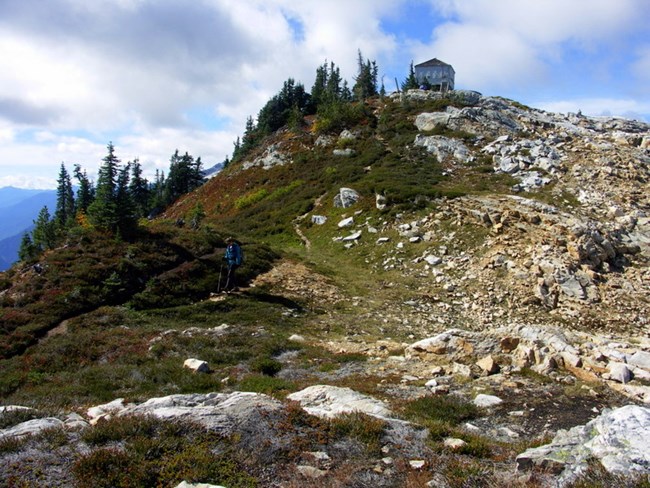 A hiker below Sourdough Mountain Lookout, heading toward Pierce Mountain