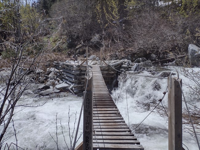The suspension bridge over a rushing creek.