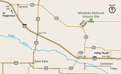 Area map of the Minidoka National Historic Site in Idaho. The map is tan and the park is a small green square with short arms at each lower corner in the upper right quadrant of the map. Roads and highways are represented by dark yellow lines and towns by yellow dots.