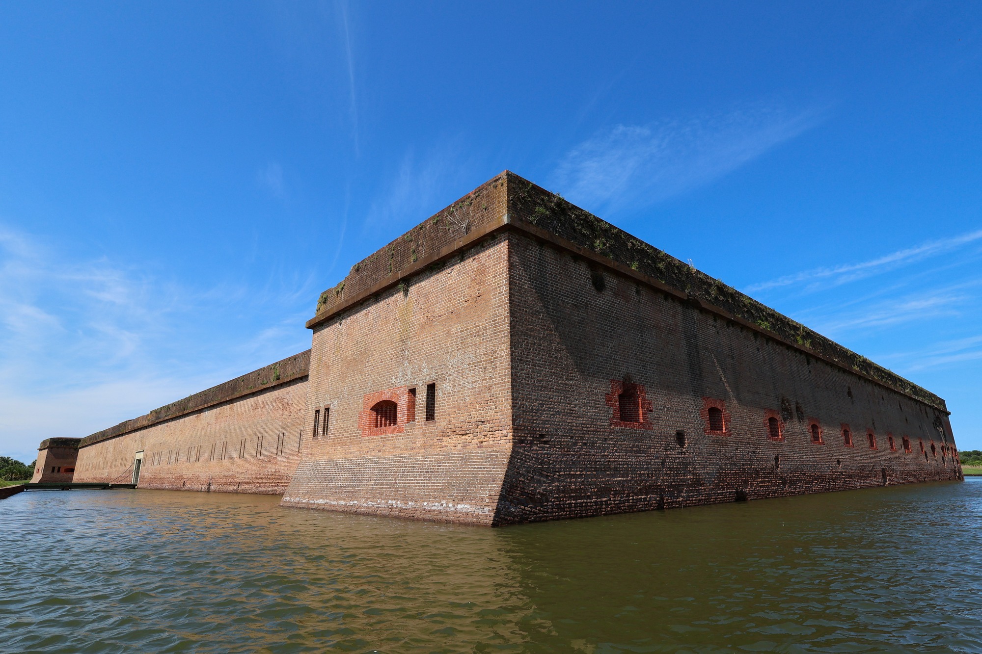 A moat surrounds a large brick fort.