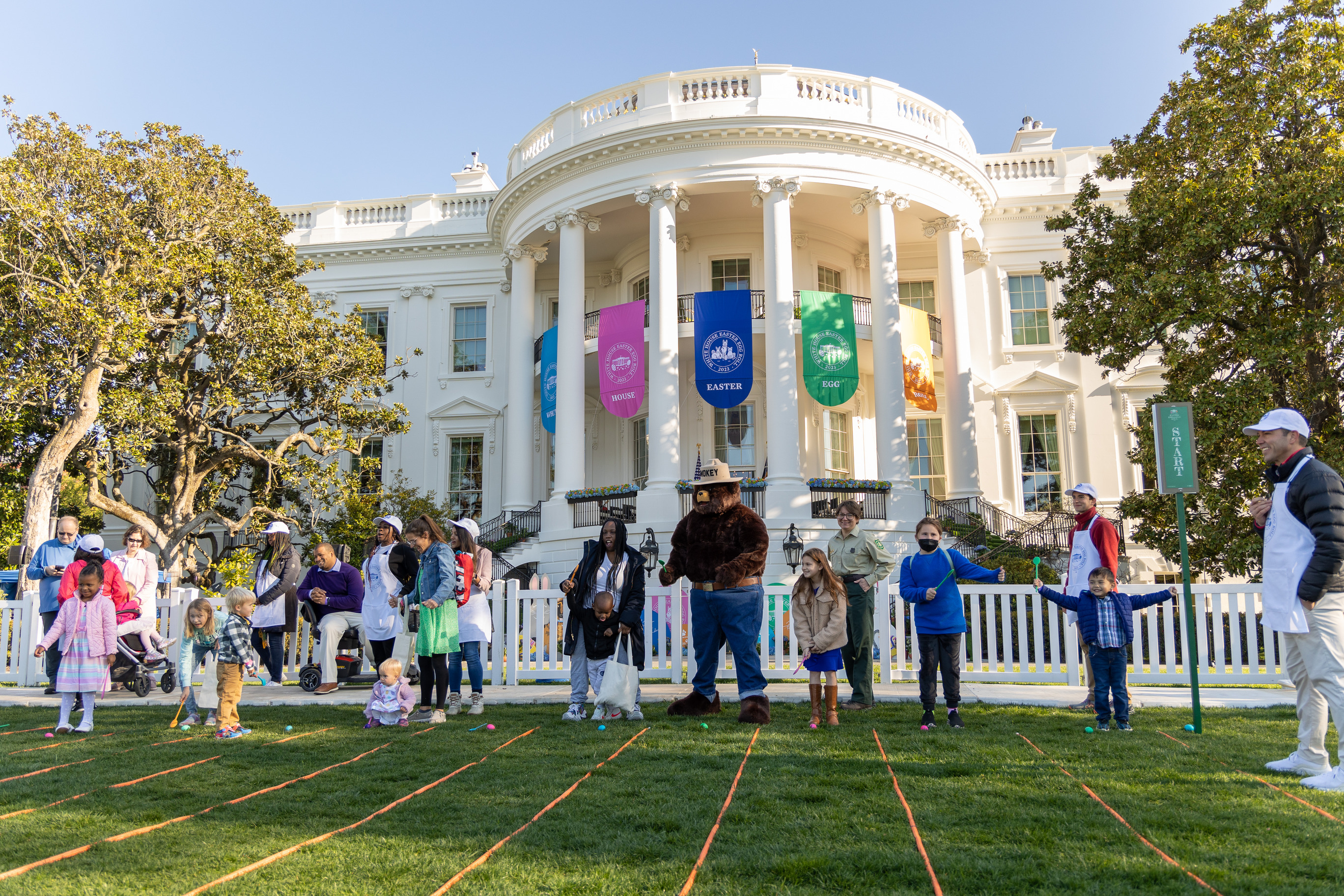 Visitors stand in front of the white house getting ready to play a game 