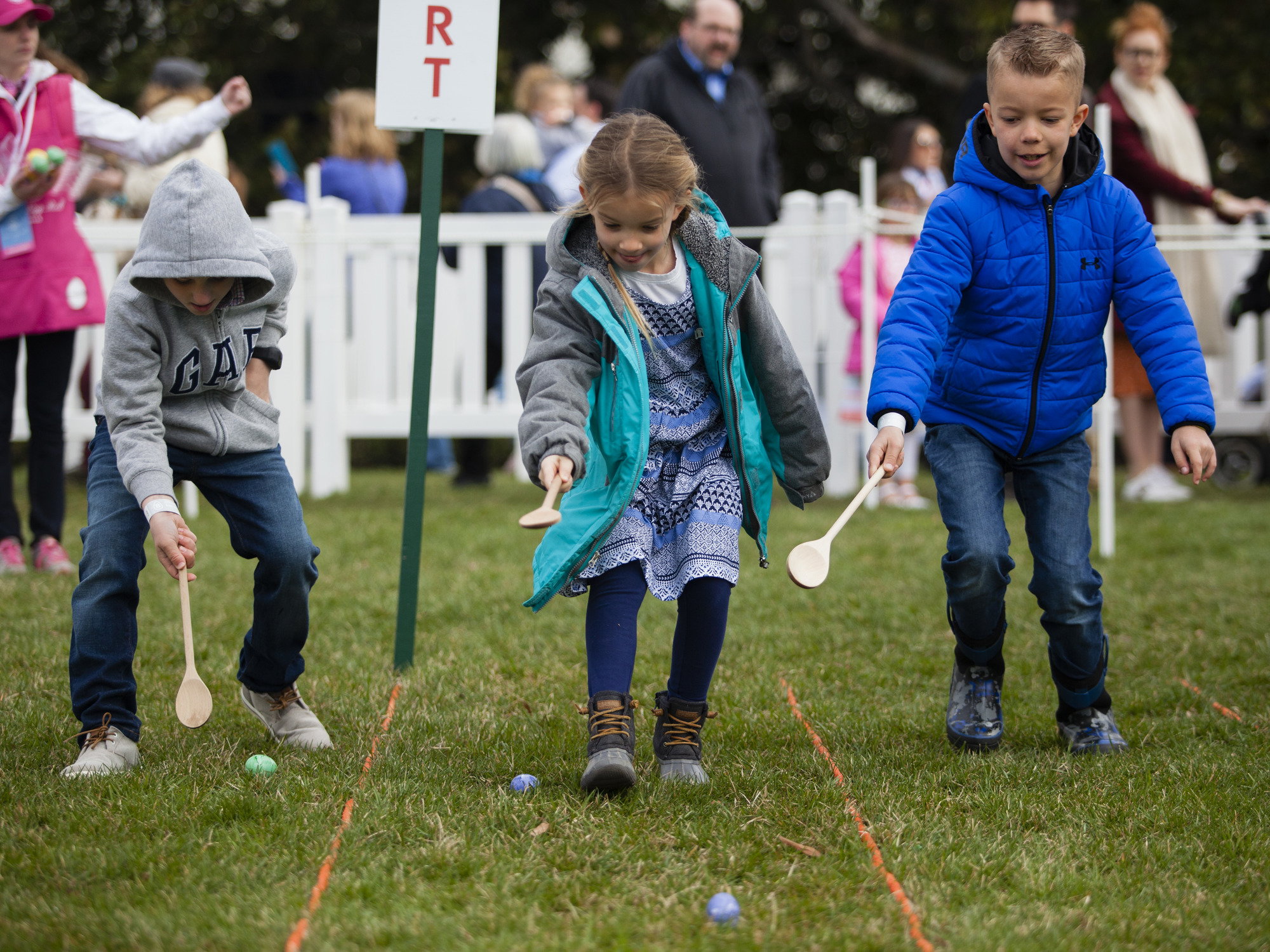 Three children participate in the Egg Roll. 