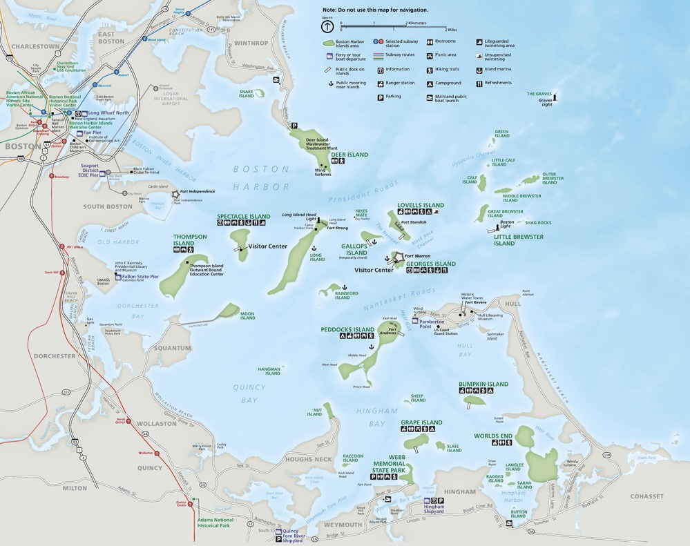 Park map of Boston Harbor Islands National Recreation Area, showing the bays, inlets, islands, and landmarks in and around Boston Harbor. Indicated in brown, the harbor curves like a C from the top left corner to the bottom right of the map. Two dozen islands scattered throughout the harbor are green and the water is blue. 