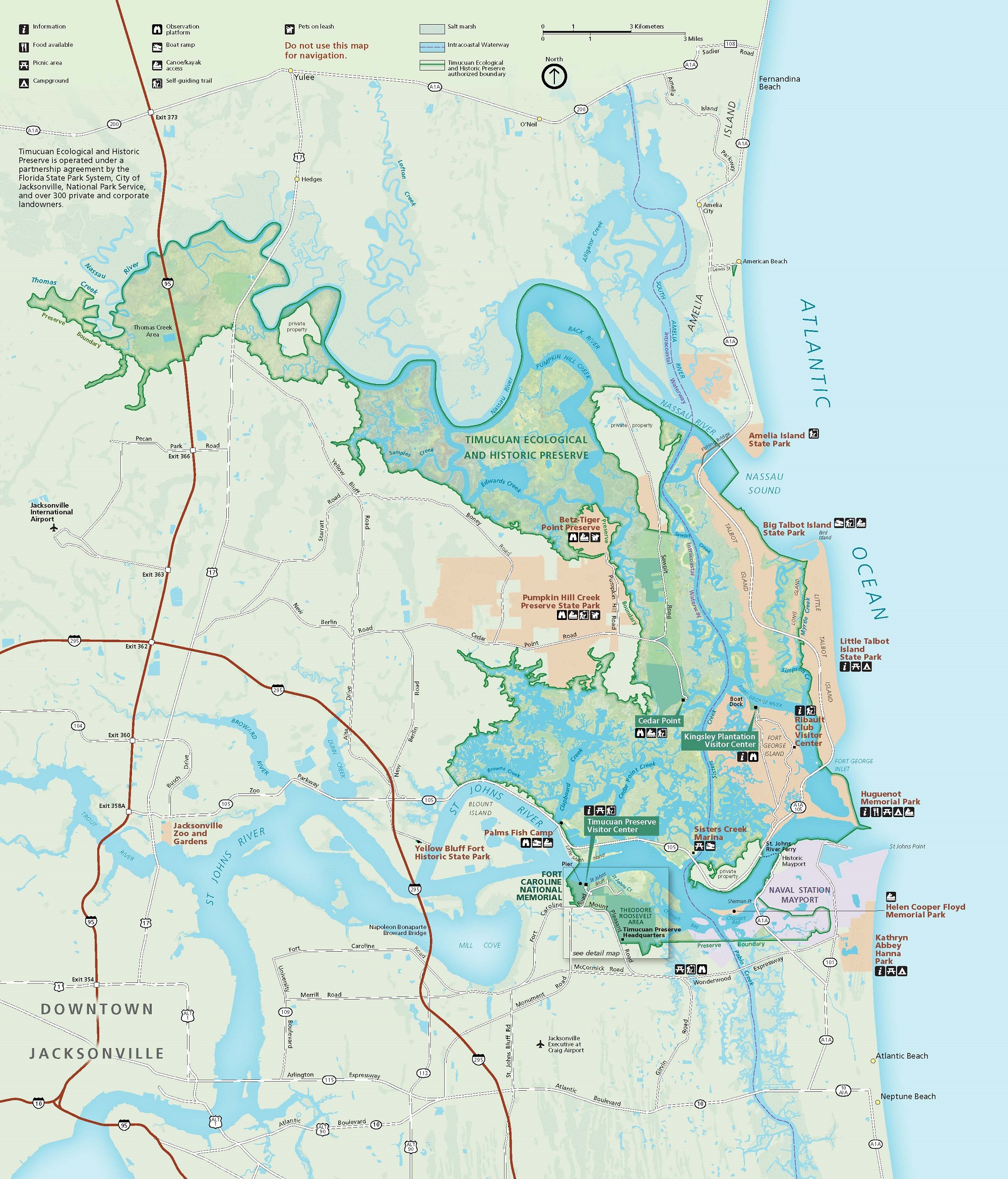Map of Timucuan Ecological and Historic Preserve in Florida. The park, an irregular hook shape, is lime green with acid wash-like speckling within a swirl of peach, lavender, and cyan, surrounding lands pale sage with burgundy highways. The sky-blue Atlantic Ocean runs along the right edge of the map.