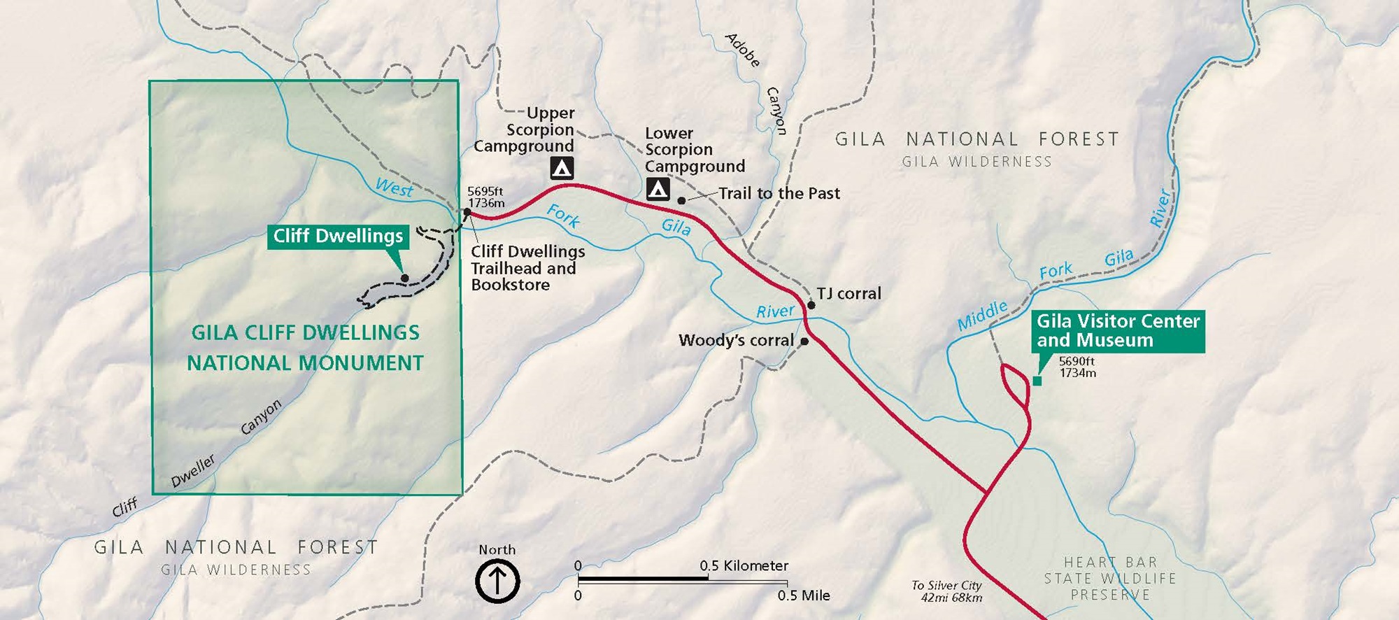 Map of Gila Cliff Dwellings National Monument in New Mexico. Two green, rectangular areas are outlined in darker green. Heart Bar State Wildlife Preserve is shown in pale mint green and connects them along West Fork Gilar River. Surrounding areas are beige, waterways are blue, and roads are red.