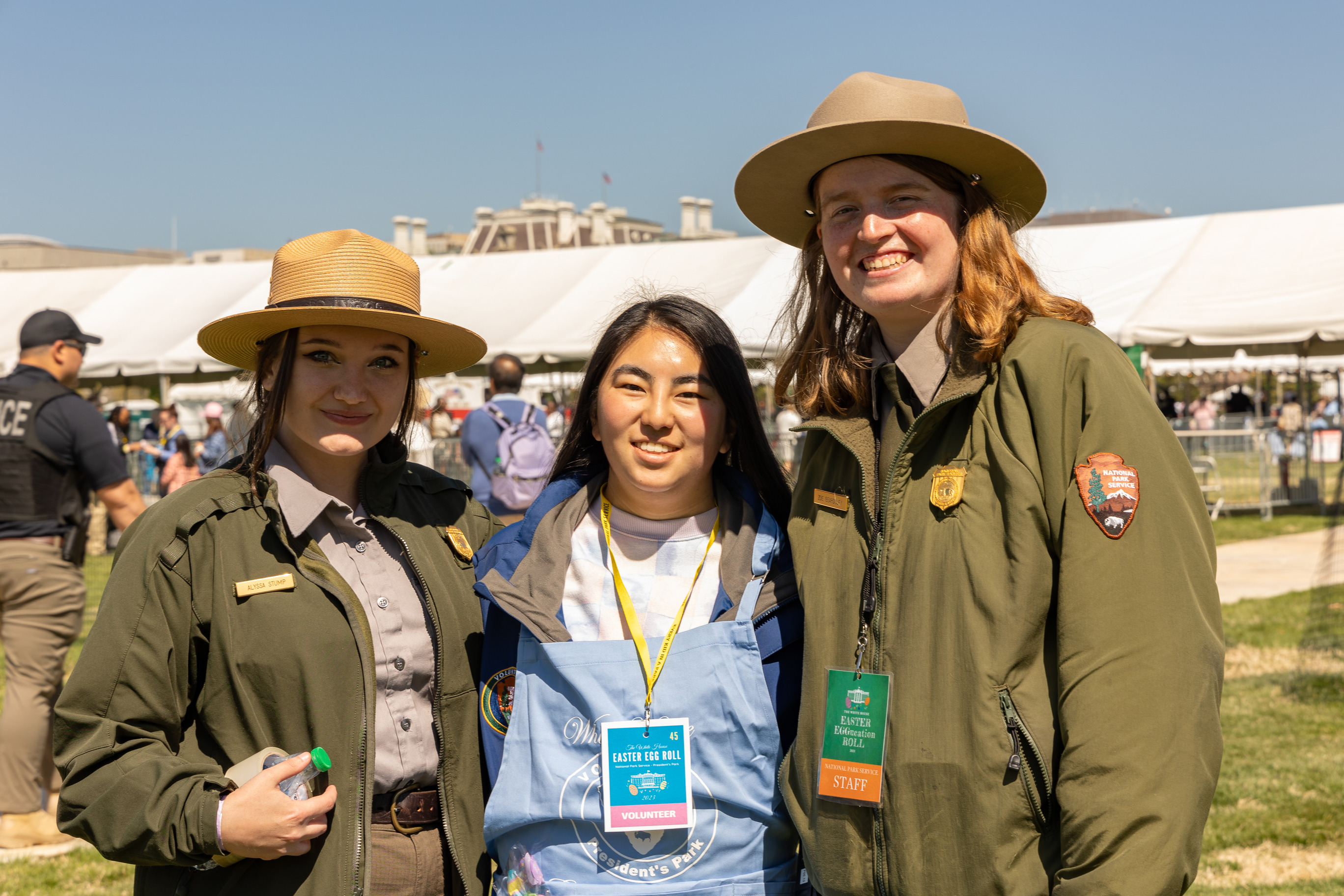 Two park rangers and a volunteer smile 