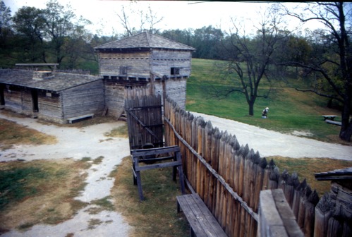 Image of a blockhouse and pointed palisade of a frontier fort.