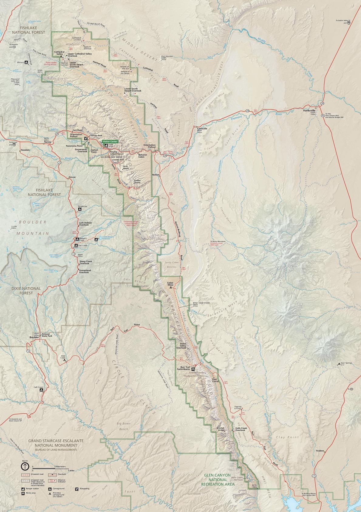 Map of Capitol Reef National Park in Utah. Outlined in green, the narrow park runs diagonally with stepped edges from the top left corner of the map to near the lower right. Terrain is shown in shades of beige and taupe. Paved roads are represented with red lines, and water features are blue.