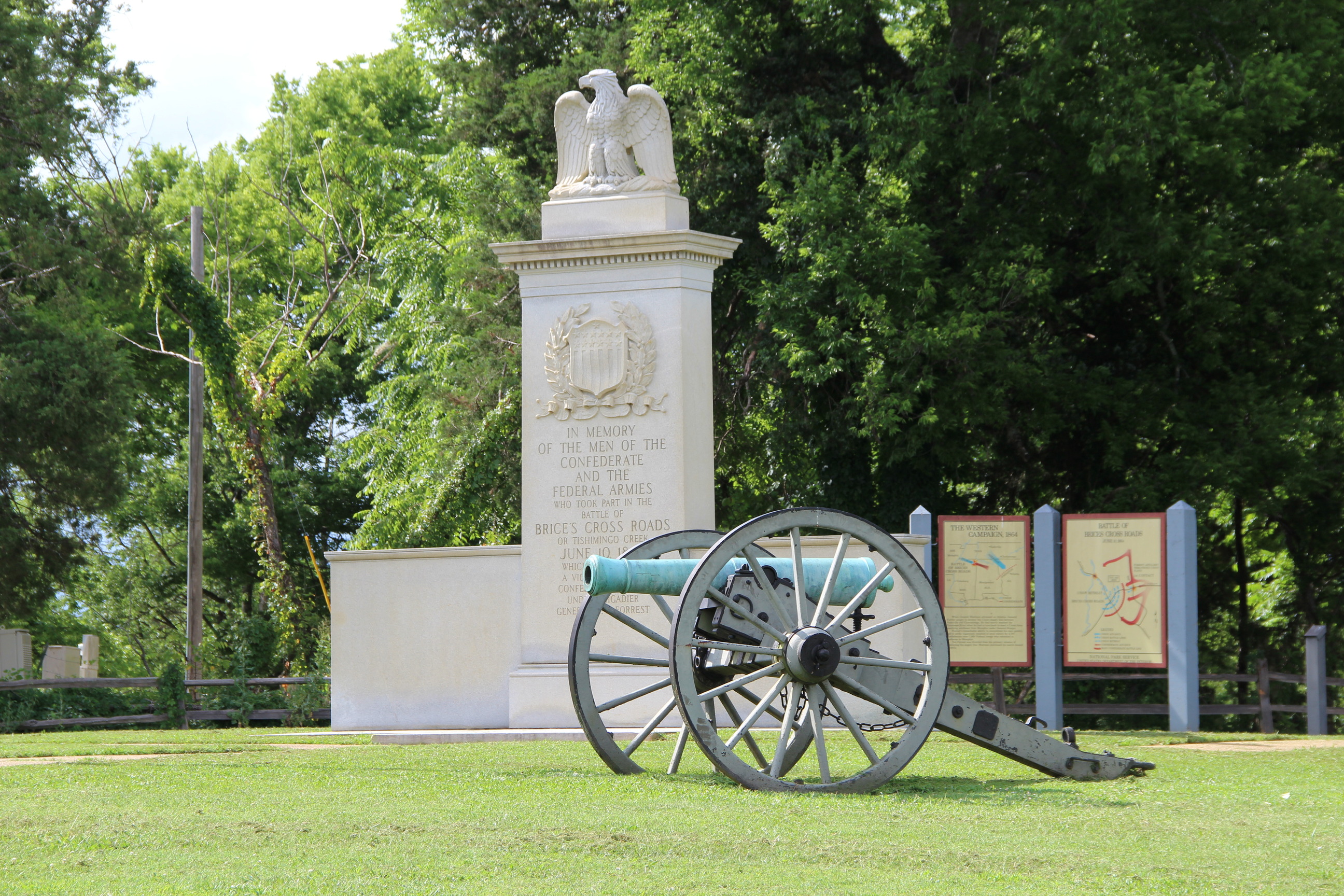 A full color photograph of a marble monument and a Civil War-era cannon.