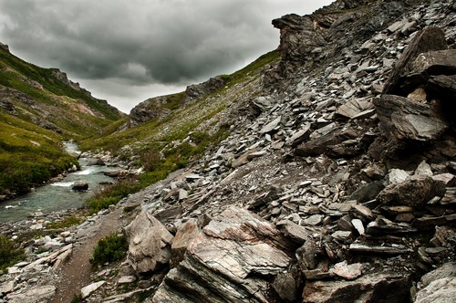 rocky, tree-less mountains on either side of a shallow river
