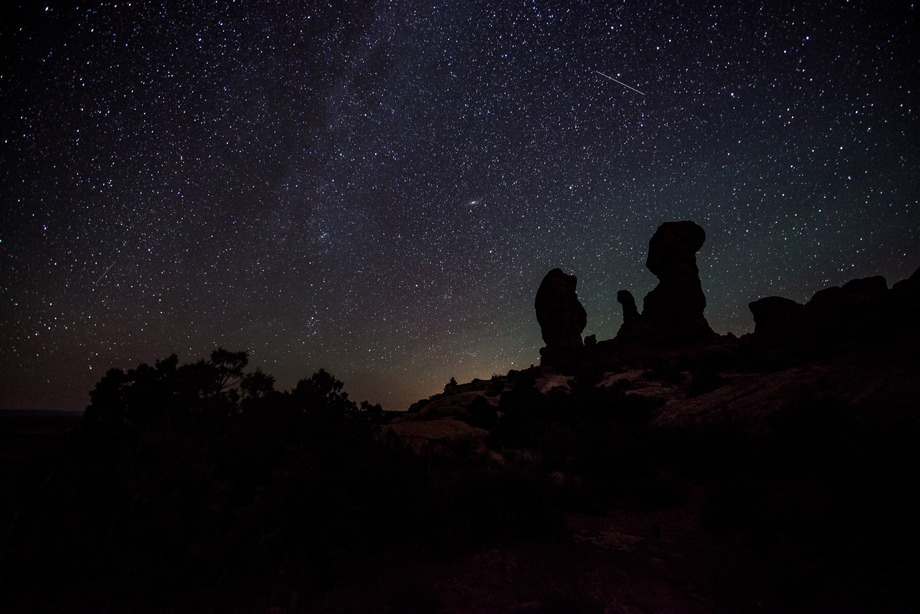 the milky way arcs above silhouetted rock pinnacles