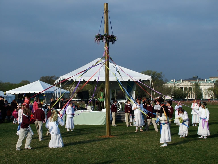 People participate in a Maypole Dance. 