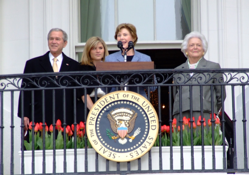 President George W. Bush and First Lady Laura Bush welcomes participants as Jenna Bush and former First Lady Barbara Bush looks on at the annual White House Easter Egg Roll March 24, 2008 on the South Lawn of the White House in Washington, DC.