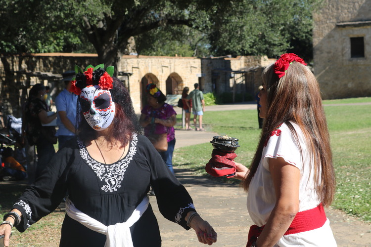 Woman blessing another woman with sage and smoke. 