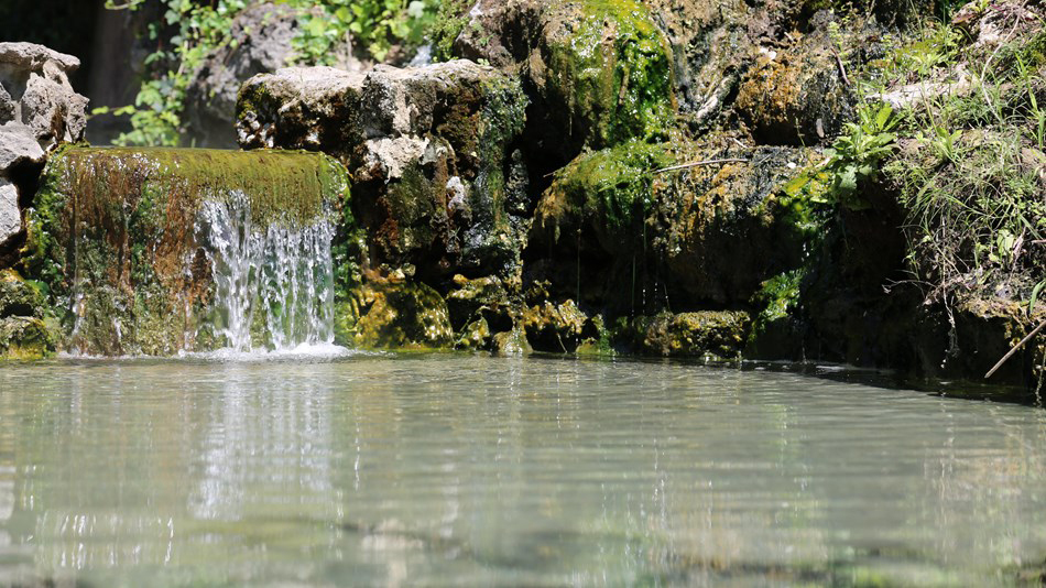 close up view of hot spring pool with small waterfall