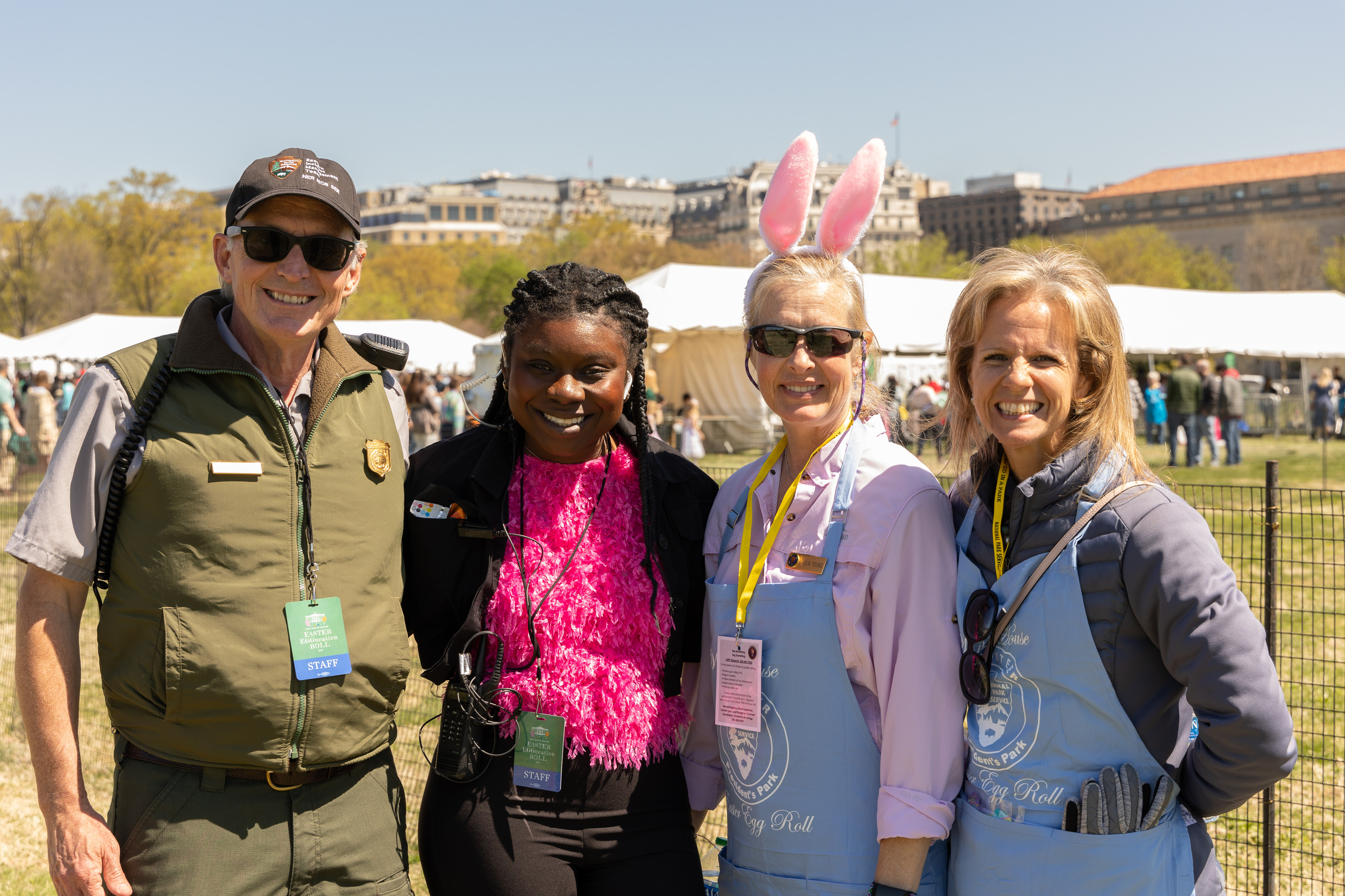 A park ranger and three volunteers smile