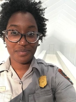 Black woman in a park ranger uniform.