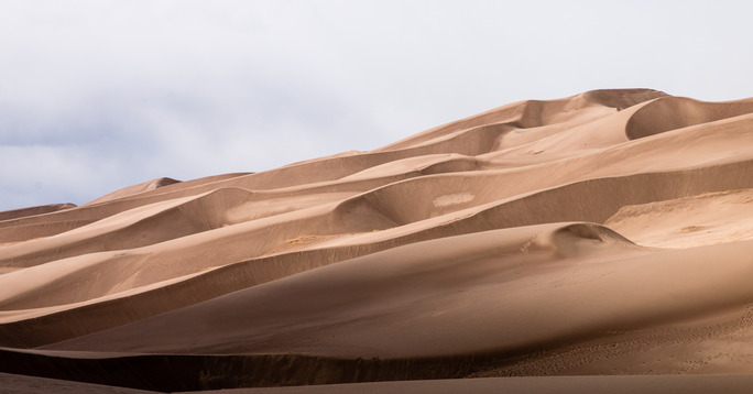 The sun shines on the Great Sand Dunes. 