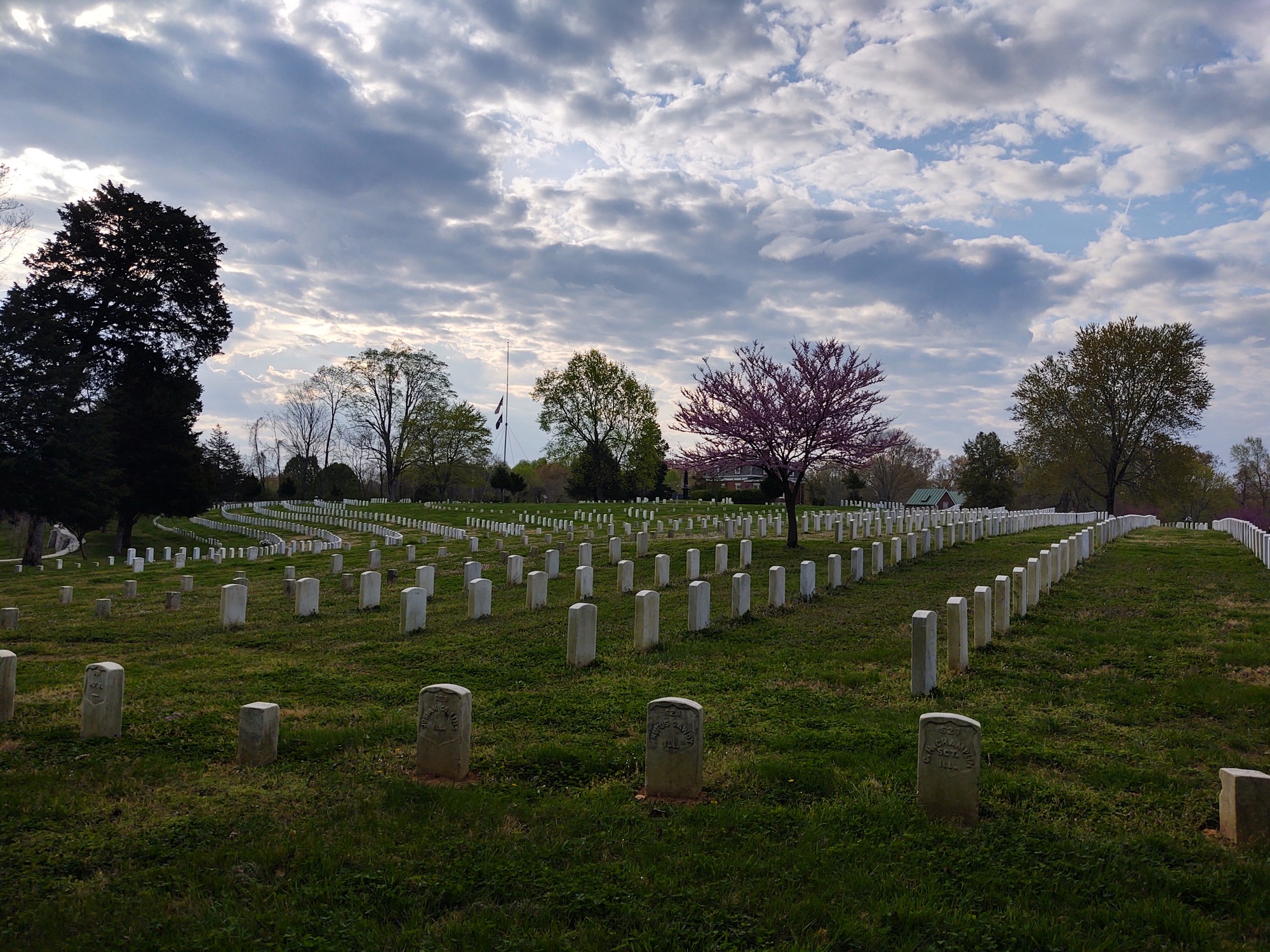 headstones in cemetery with blue skies and clouds