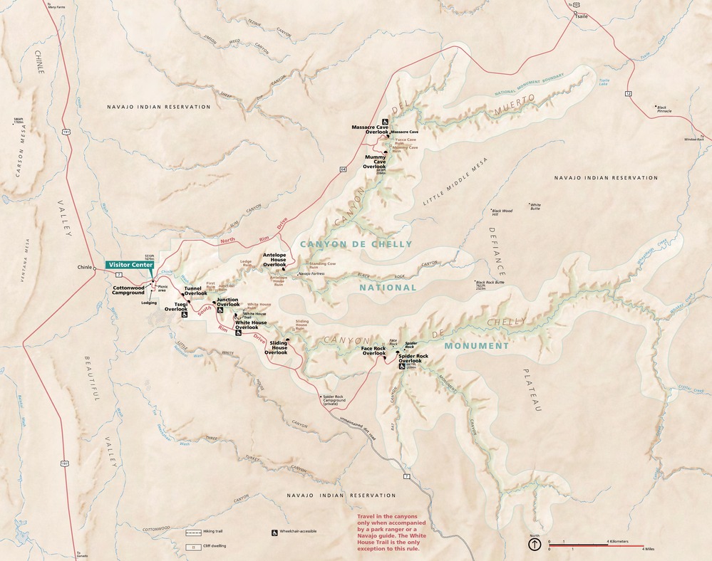 Map of Canyon de Chelly National Monument in Arizona. Composed of spindly branches, the monument area is shown in beige with the thin blue line of Chinle Wash running through the pale green and brown ridges along each appendage.