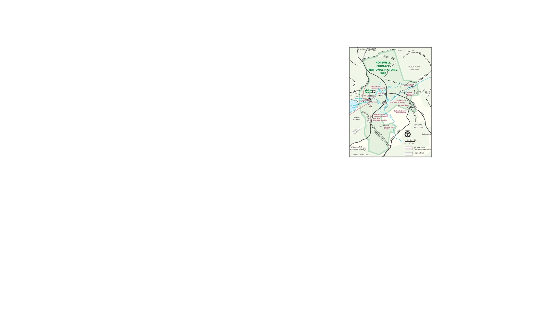 Map of Hopewell Furnace National Historic Site in Pennsylvania. The park is outlined in green with the surrounding area in a lighter shade of green. Roads are represented by black solid lines and trails by black dashed lines.