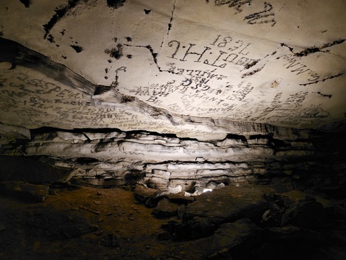 Historic signatures written on the walls and ceiling of the cave passage. 