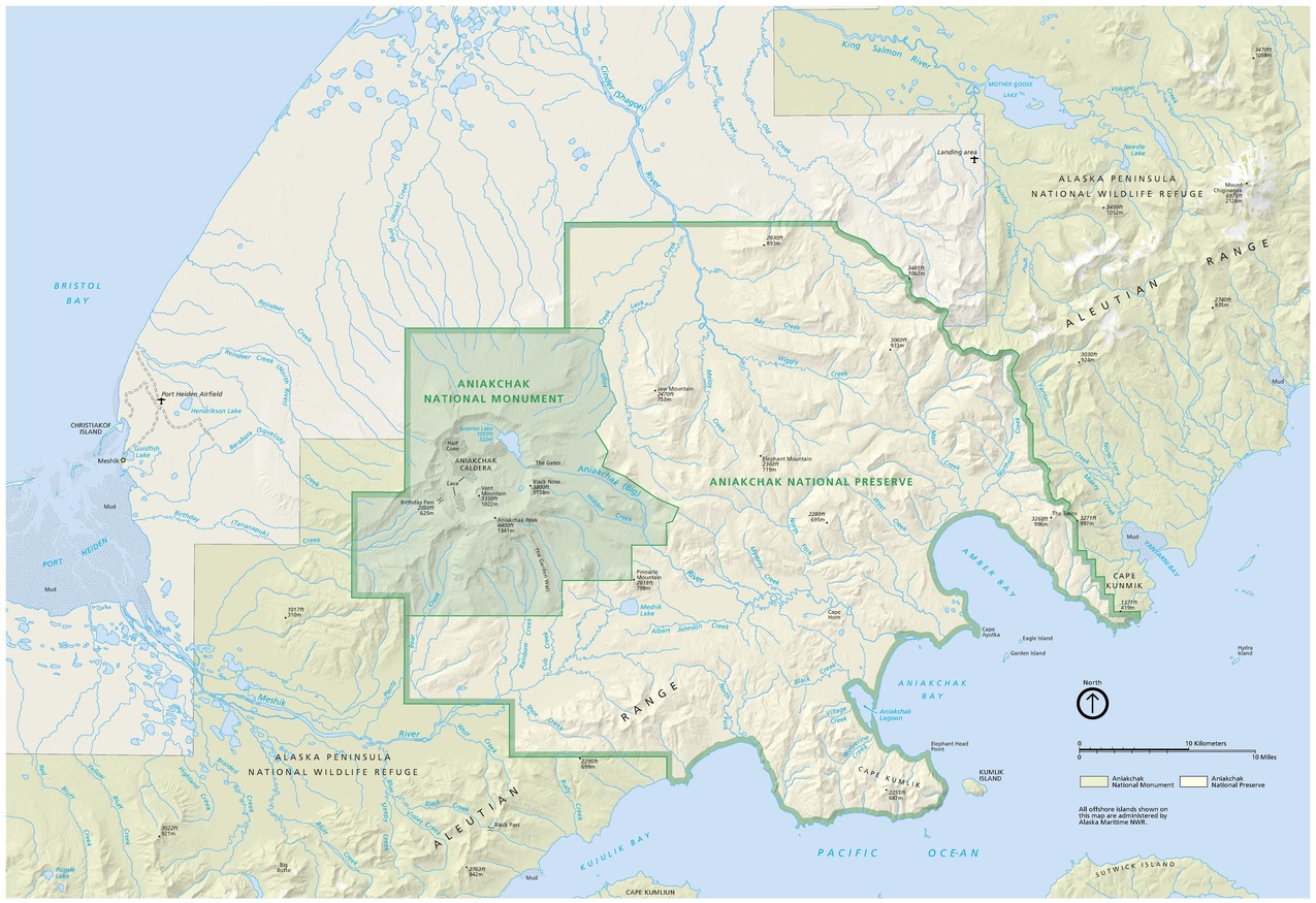 Map of Aniakchak National Monument and Preserve in Alaska. Framed by the powder blue waters of Bristol Bay to the northwest and the Pacific Ocean to the southeast, a segment of the Alaska Peninsula spans the map from the southwest to the northeast corners.