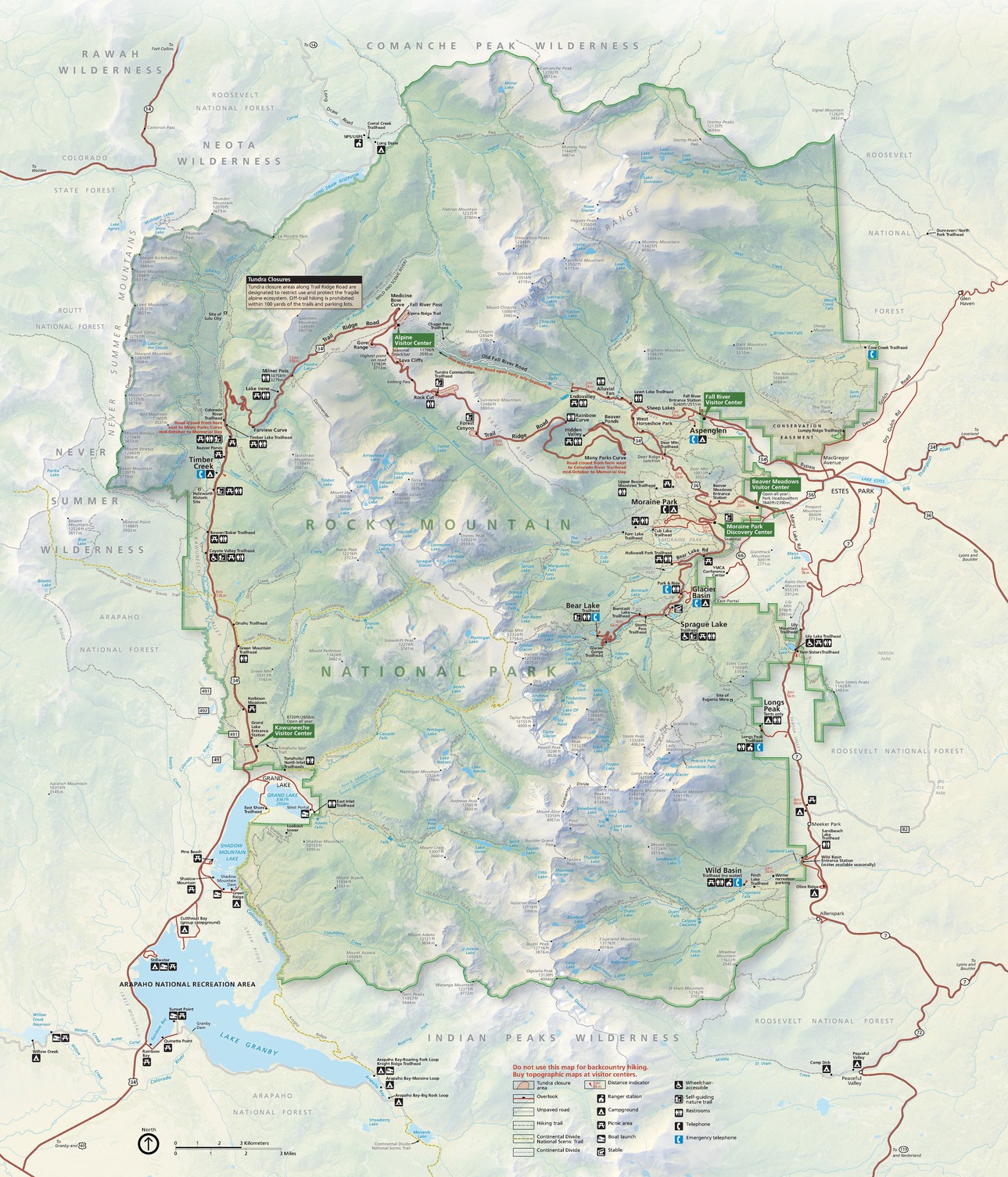 Map of Rocky Mountain National Park in Colorado. The park comprises a large area, arced at the top and mostly squared across the bottom, highlighted in light green and dominated by a north-south mountainscape depicted with shaded relief, with the highest peaks in white and gray mountainsides beneath them. Surrounding lands are pale green or yellow, and roads are shown in red.