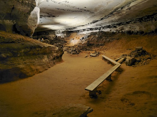 A large wooden bench in a cave passage. 