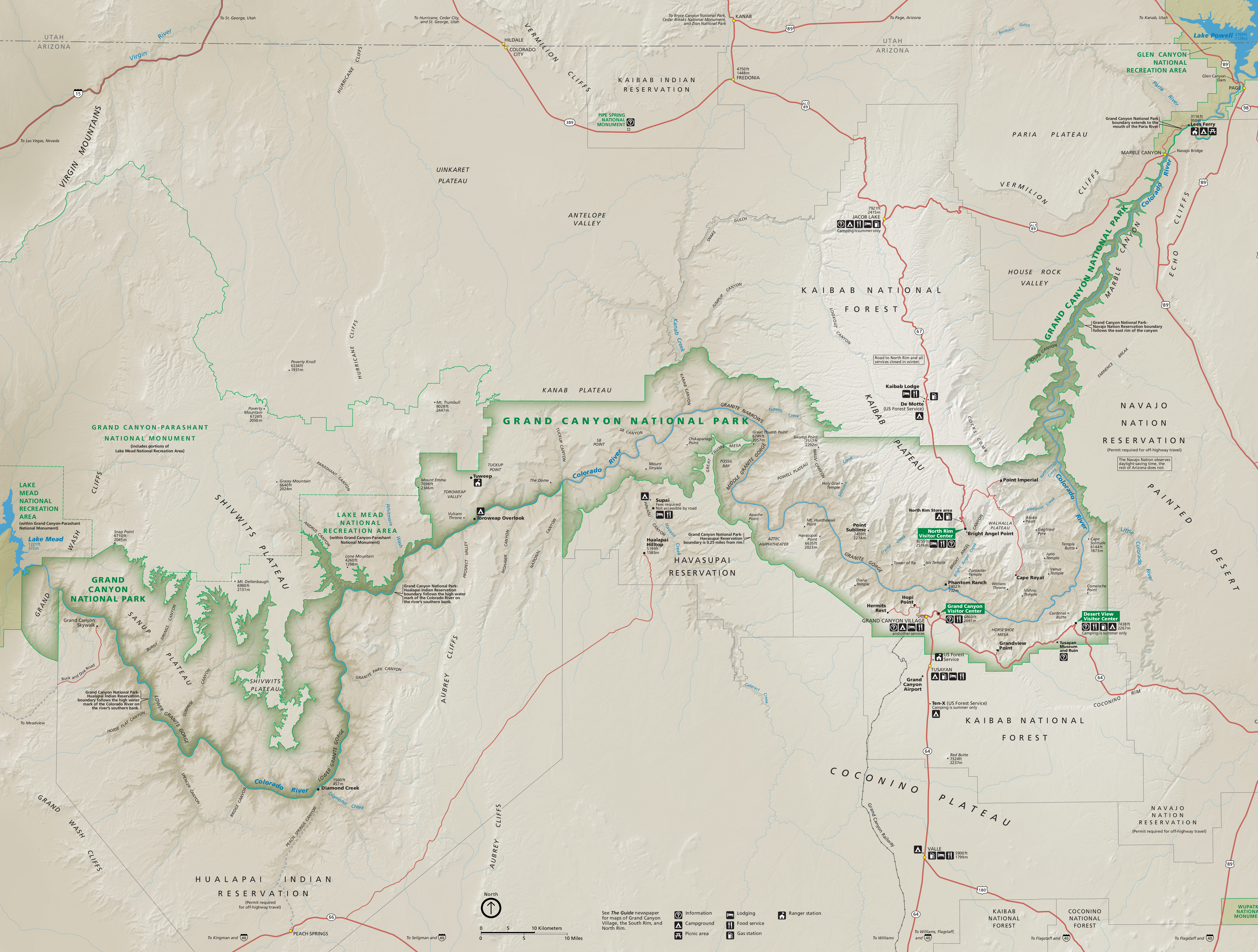 Map of Grand Canyon National Park in Arizona. Outlined in green, the park follows the shallow, sideways S-curve of the Colorado River across the middle of tan-colored terrain. Dozens of peaks, plateaus, points, overlooks, cliffs, gorges, bodies of water, reservations, valleys, and other sites are labeled across and around the park.