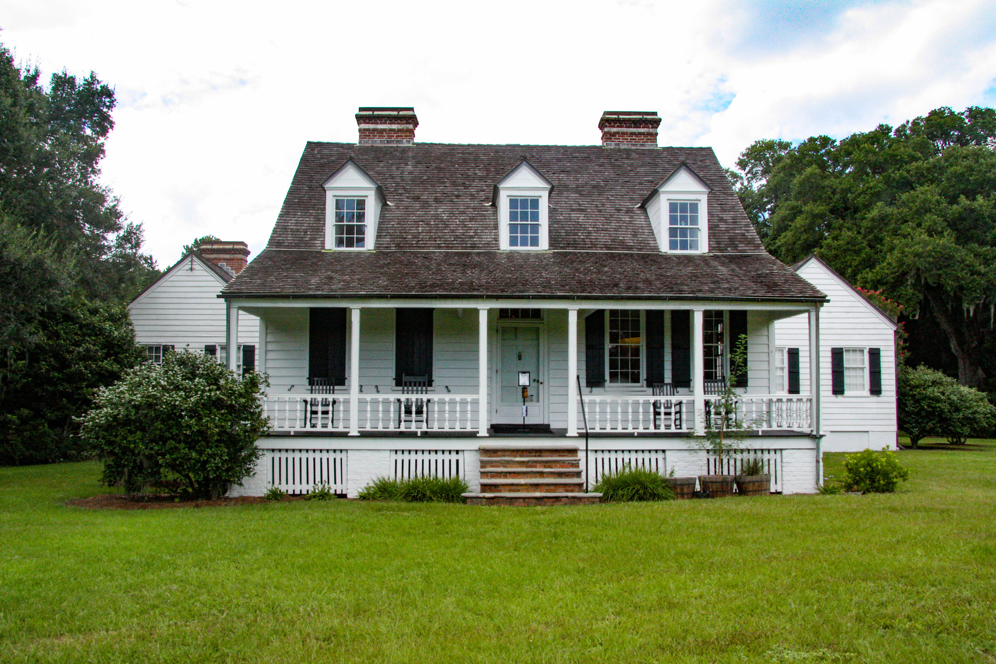 Historic farm house with a prominent porch and two wings