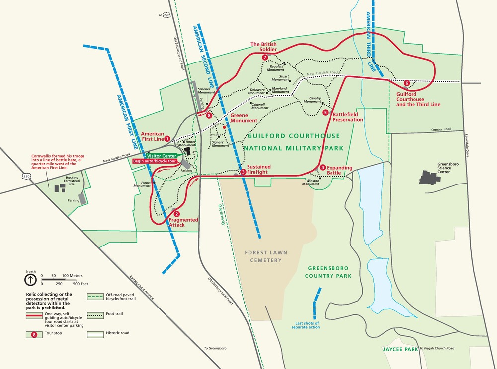 Map of Guilford Courthouse National Military Park in North Carolina. The park is shaded green with the neighboring Greensboro Country Park shown in lighter green and Forest Lawn Cemetery in tan. A self-guiding tour route represented in red passes eight numbered sites, and three blue dashed lines indicate lines of battle.