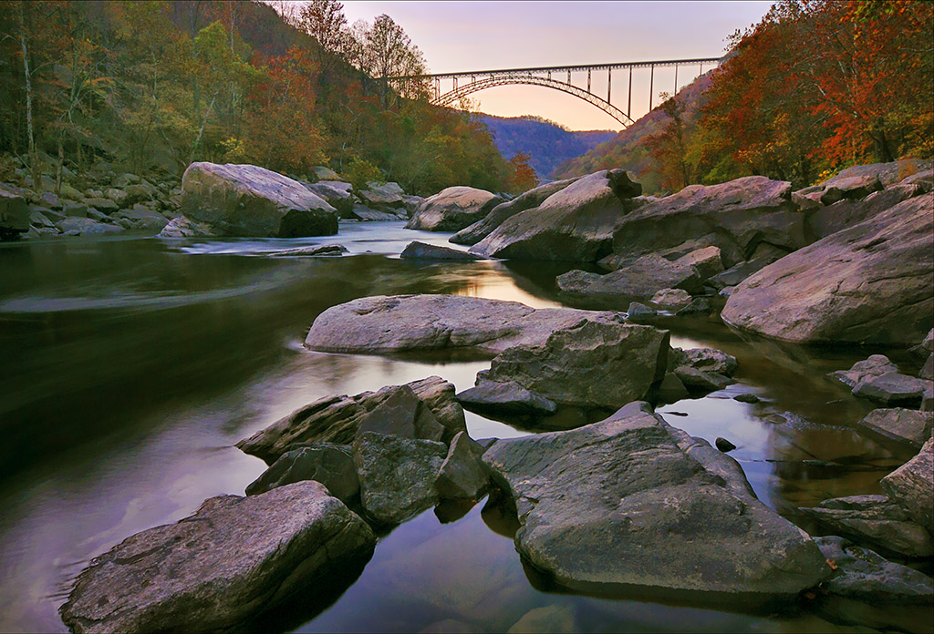 a bolder choked gorge with bridge in background