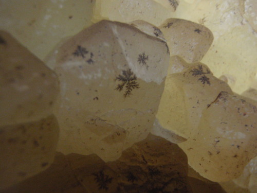 Opaque crystal with black spots.