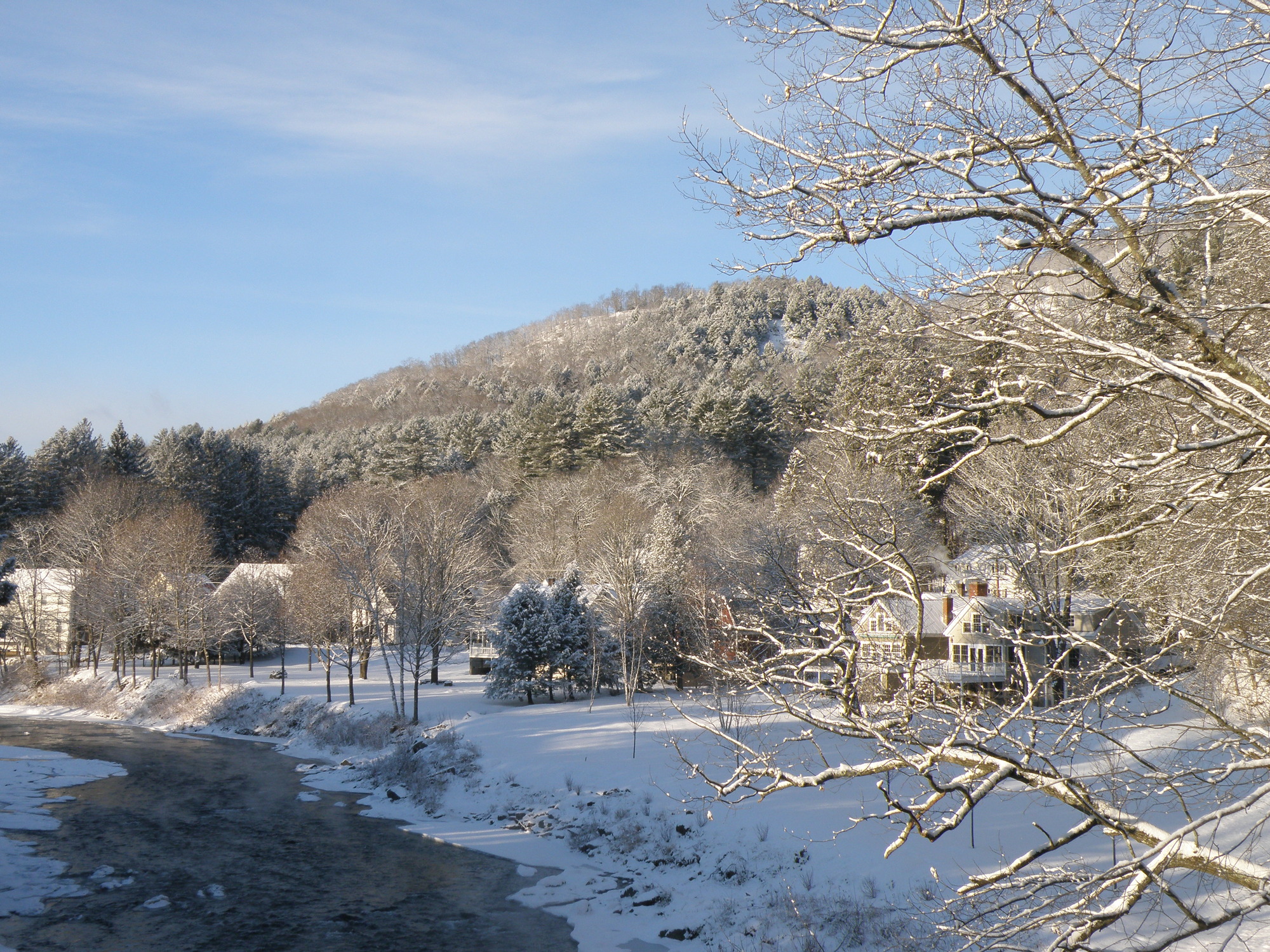 Winter mountain landscape with small river in foreground