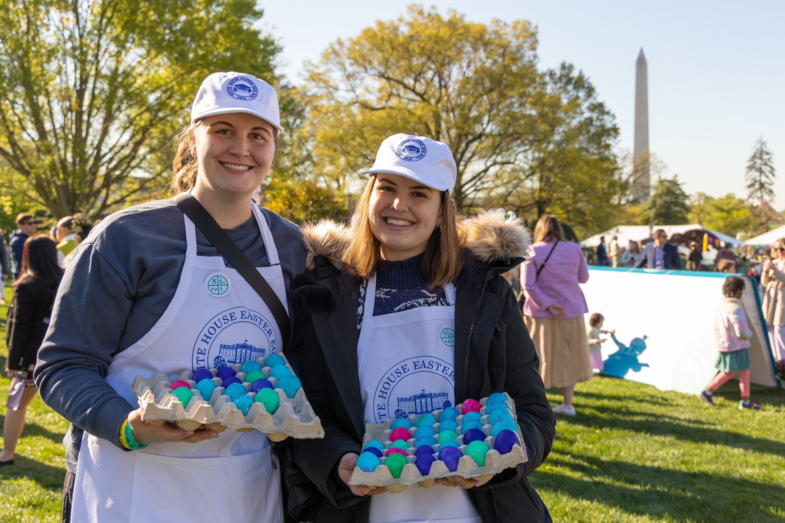 Volunteers pose with cartons full of colorful easter eggs