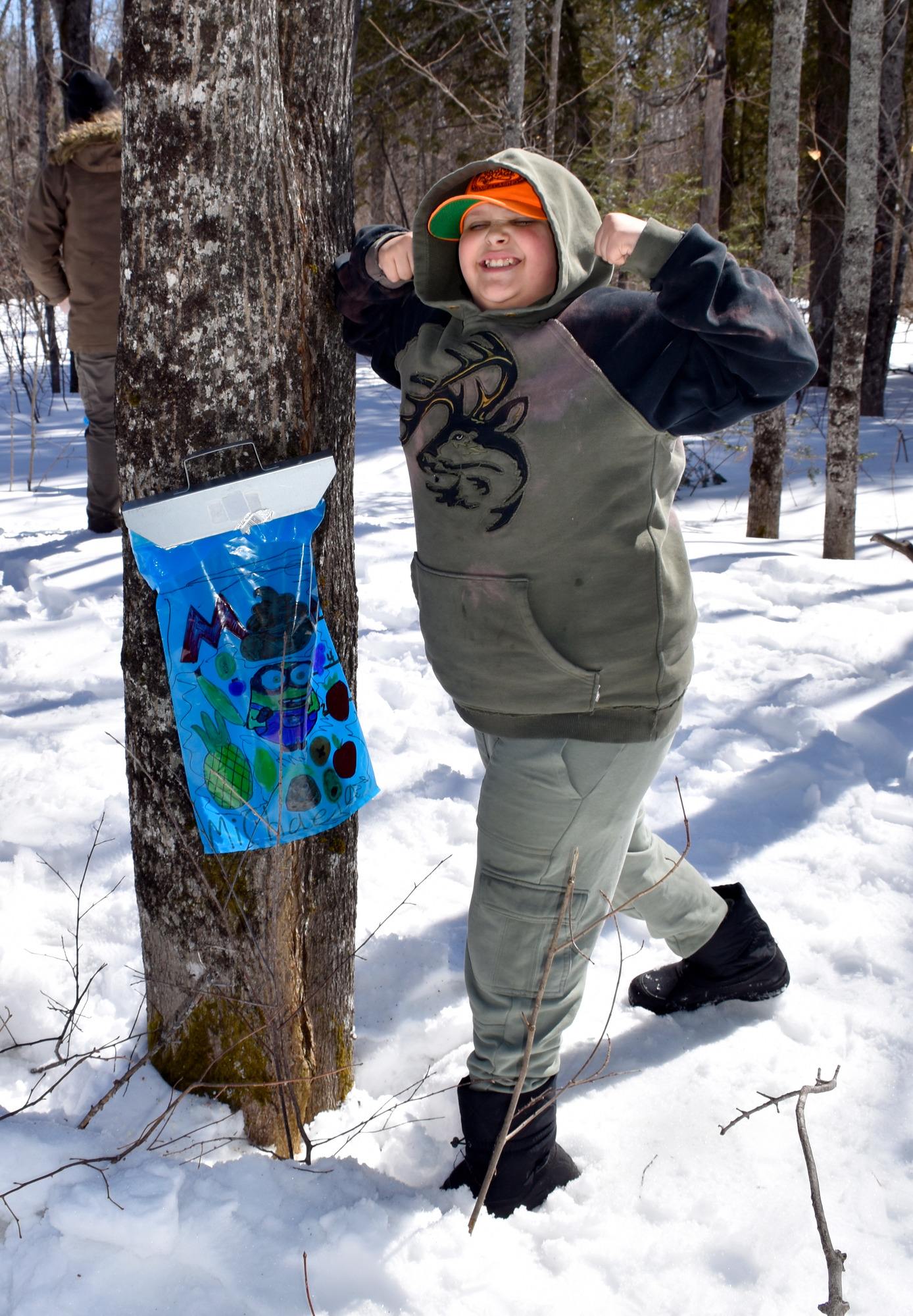 A child smiles and holds up both arms in a position of strength.