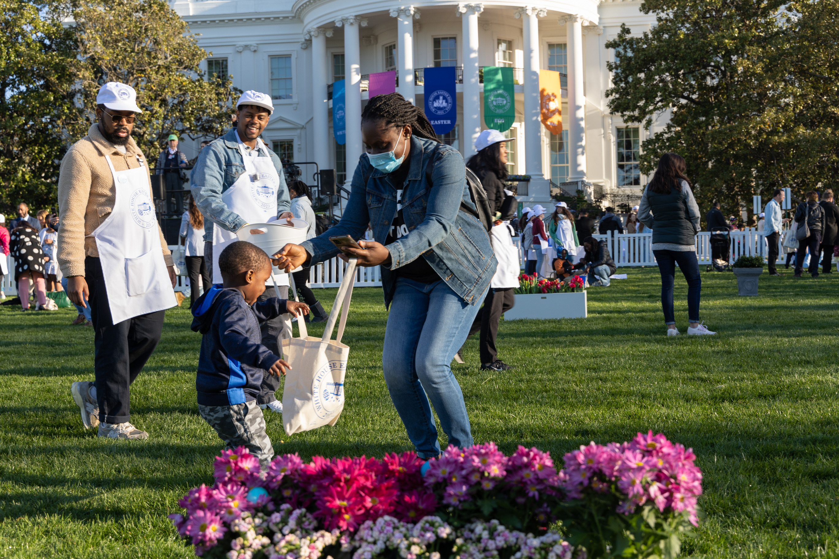 Two visitors search for Easter Eggs in front of the White House