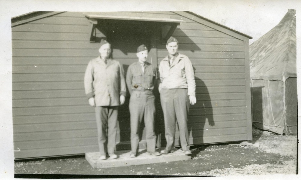 Three men in front of a building